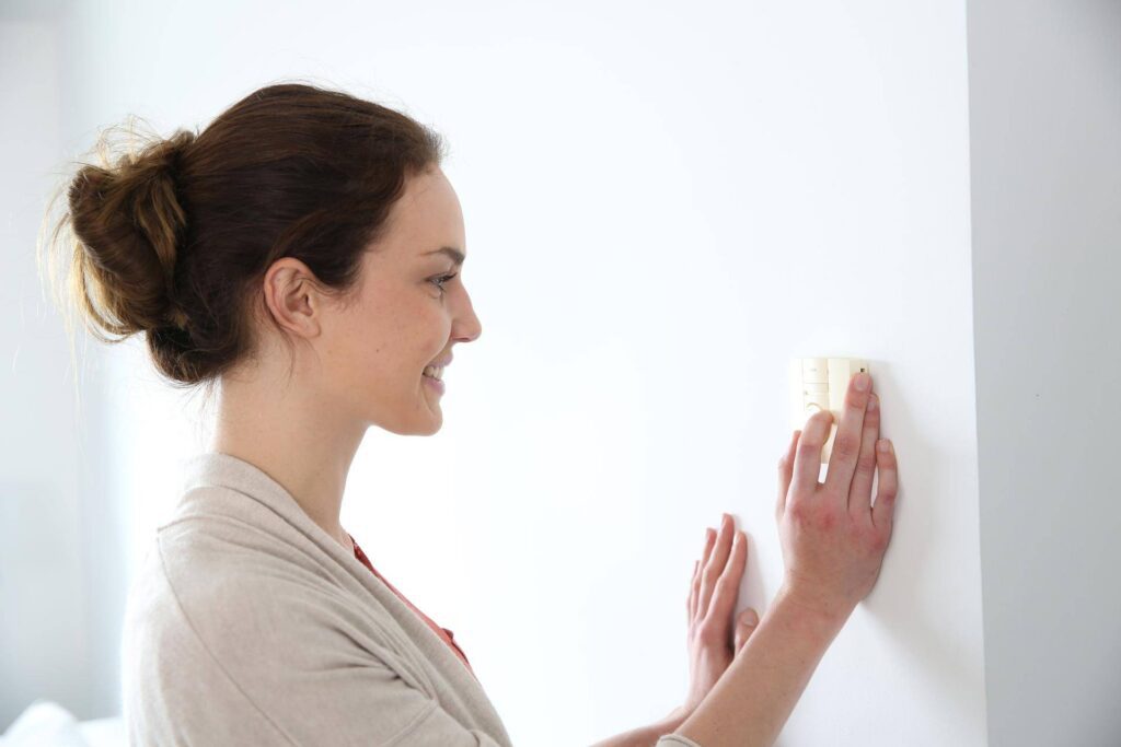 Woman checking Thermostat